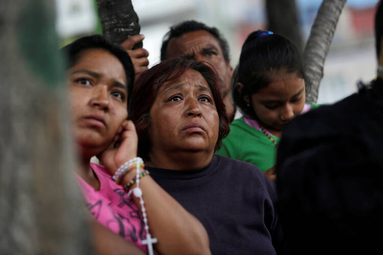 Family members of a person still trapped under the rubble of a collapsed building observe rescue team workers on Sept. 24 after a Sept. 19 earthquake in Mexico City. (CNS photo/Daniel Becerril, Reuters)