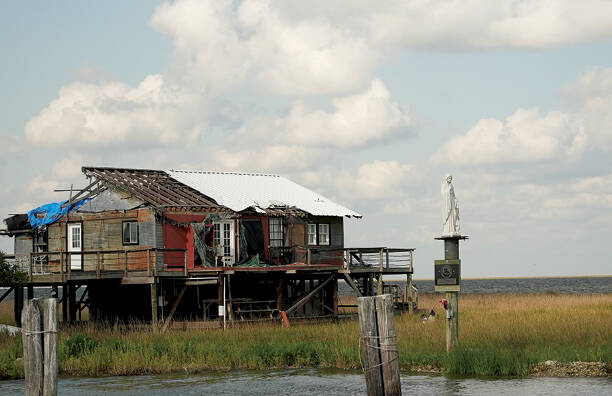 A statue of Mary stands alongside a hurricane-damaged house on the coast of southern Louisiana (photo: Kevin Jackson/America Media).