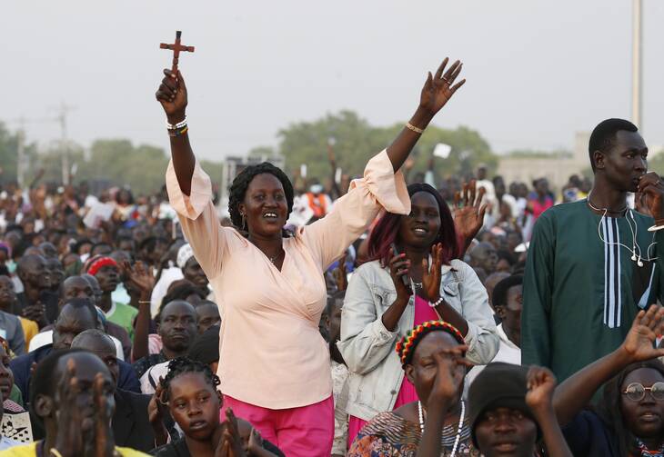 A woman raises a cross as people wait for the start of an ecumenical prayer service attended by Pope Francis at the John Garang Mausoleum in Juba, South Sudan, Feb. 4, 2023. (CNS photo/Paul Haring)