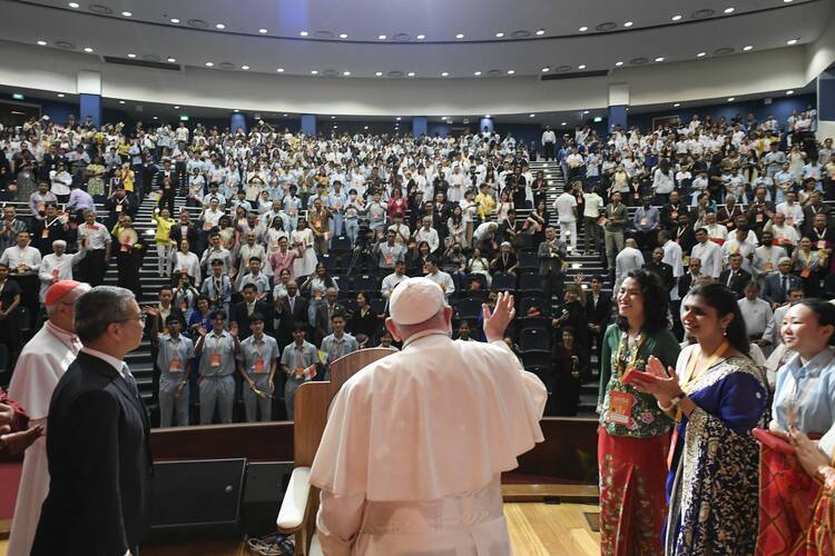 Pope Francis waves to young people gathered for a meeting on interreligious dialogue at the Catholic Junior College in Singapore on Sept. 13, 2024. (CNS photo/Vatican Media)