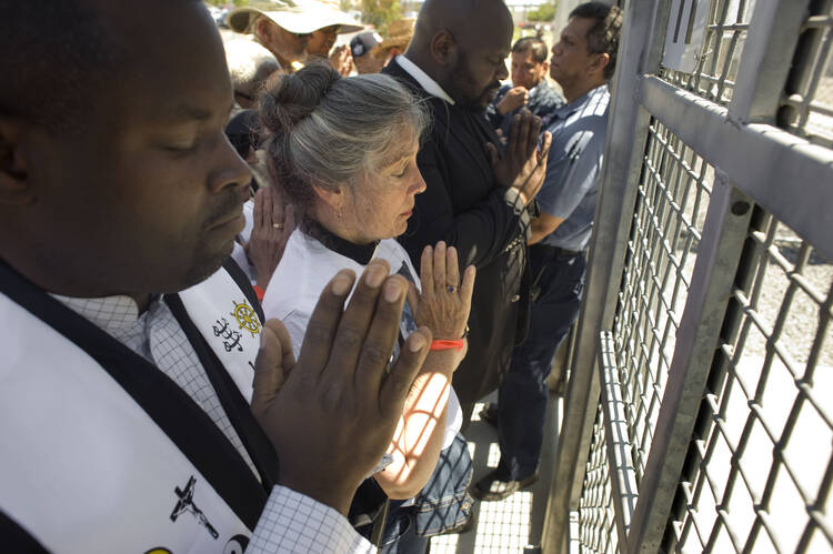  Faith leaders pray at the main entrance to the Otay Mesa Detention Center in San Diego June 23 during a march and rally in support of immigrant families who had been separated at the U.S.-Mexico border. (CNS photo/David Maung, EPA)