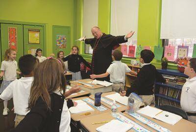 Cardinal Dolan celebrated Mass and visited classrooms during his tour of Saint Francis Xavier School in the Bronx in Oct. 2013.