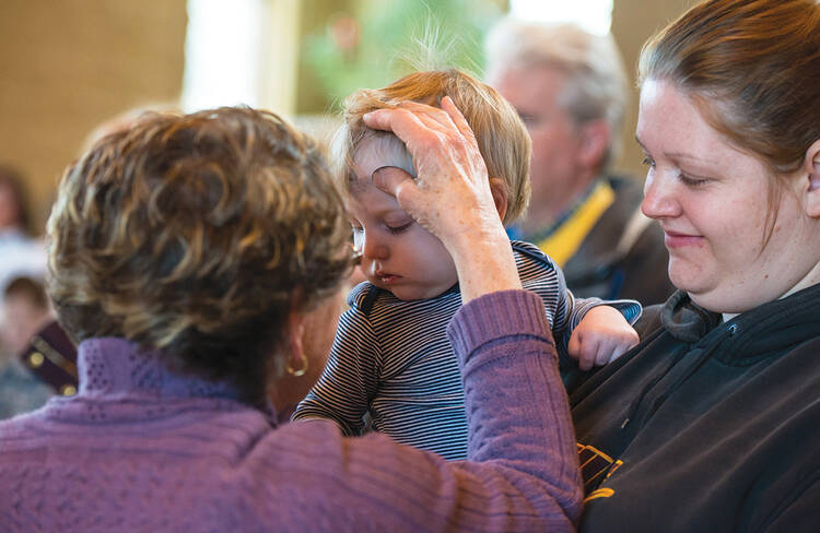 TOUCH OF GRACE. Ann Froelich, pastoral associate at St. Matthew Parish in Allouez, Wis., gives ashes.