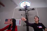 Election poll worker Indira Barrios, 17, loans a pen to a voter at the La Quinta de Guadalupe retreat and conference center in San Diego on Nov. 4, 2008. (CNS photo/David Maung)