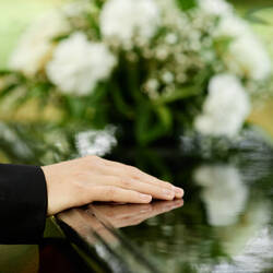 Close up of hand on coffin