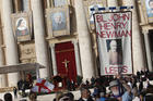  A man holds a banner showing new St. John Henry Newman before the canonization Mass for five new saints celebrated by Pope Francis in St. Peter's Square at the Vatican Oct. 13, 2019. (CNS photo/Paul Haring)