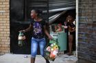 Locals run with items from a shop in Soweto, South Africa, Jan. 22. Local media reported that violence broke out Jan. 19 after a 14-year-old South African was allegedly shot dead by a foreign shop owner. (CNS photo/Siphiwe Sibeko, Reuters)